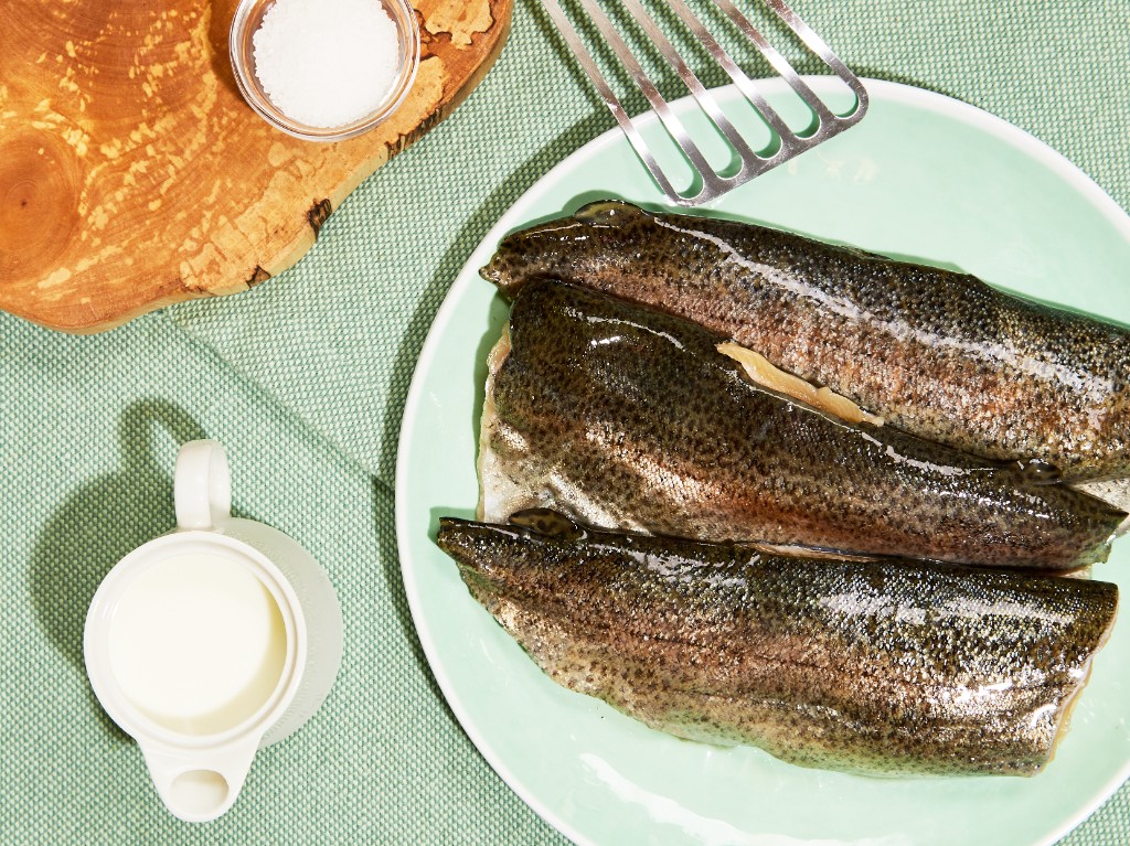 Fresh fish fillets on a plate with cream and salt